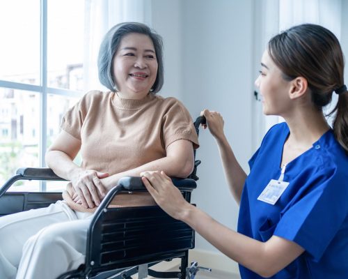 asian nurse take care senior woman on wheelchair at nursing home